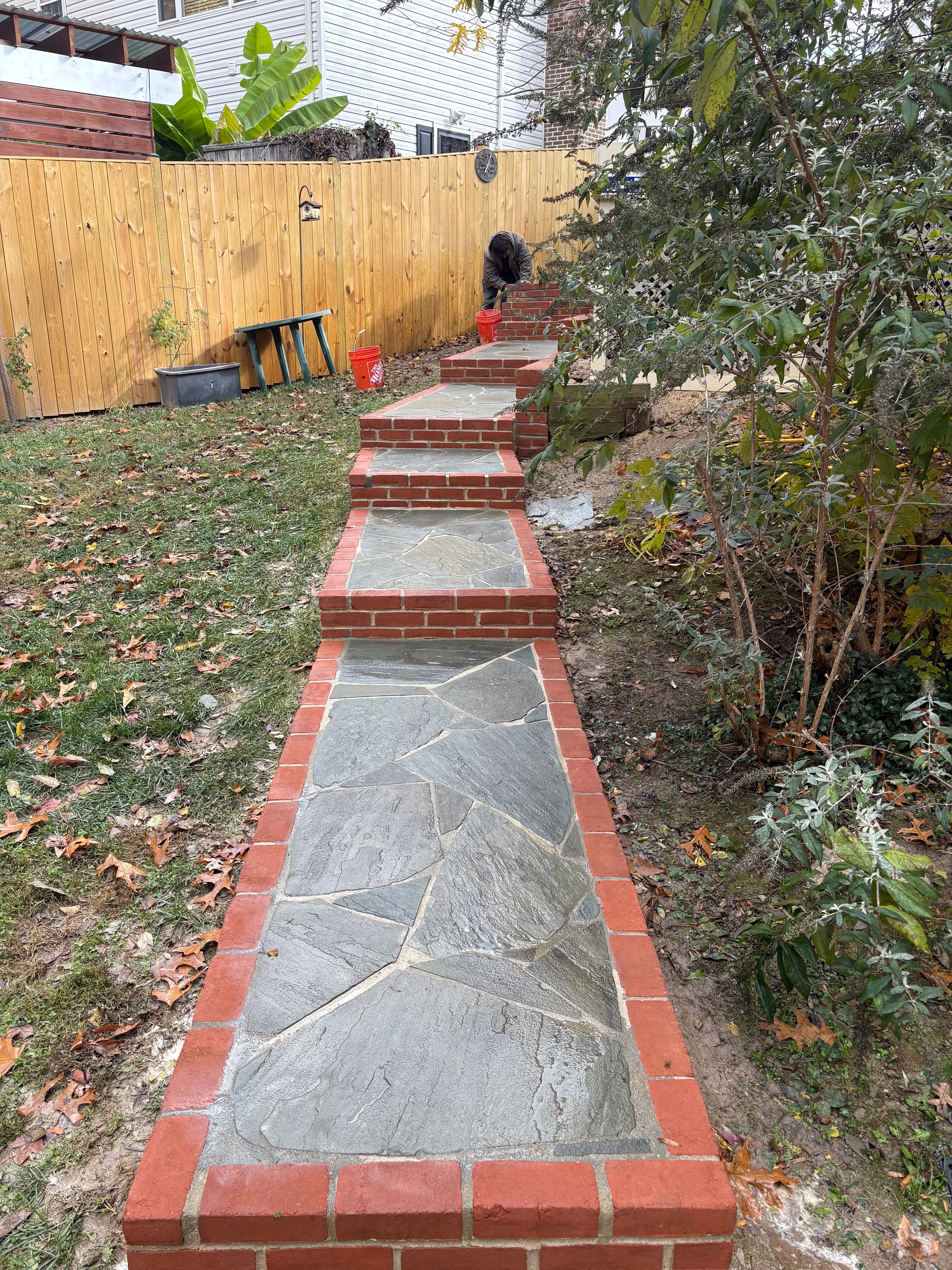 Slate and brick pathway through backyard garden with mature plantings