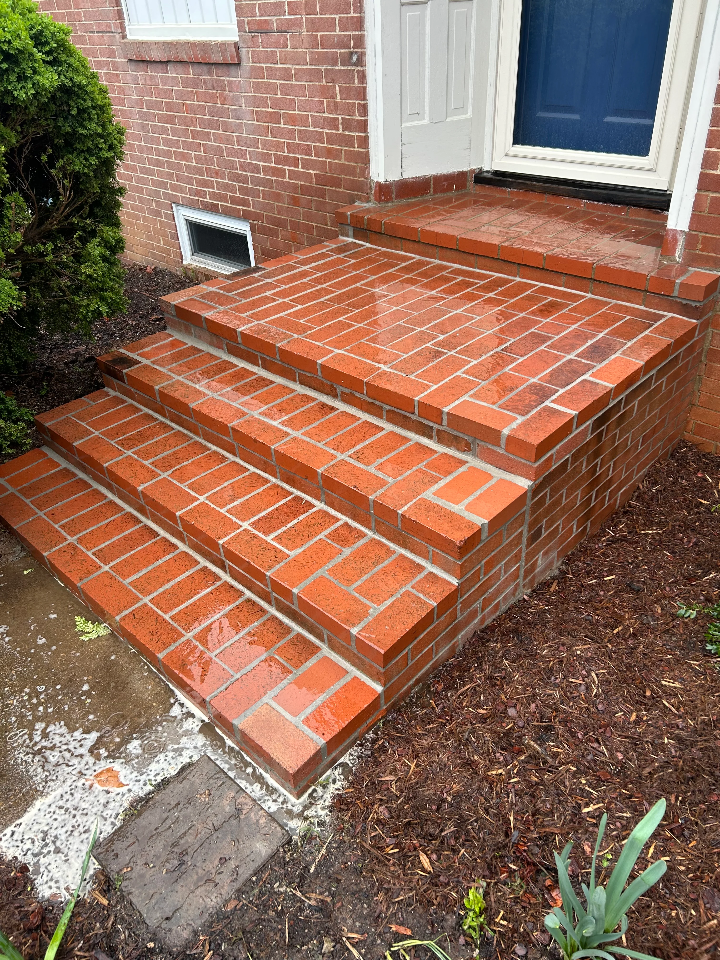 Brick patio steps and entryway with running bond pattern leading to house entrance