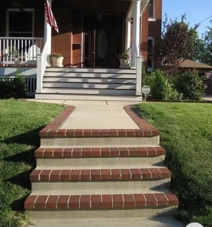 Brick and concrete front walkway with steps leading to residential home entrance